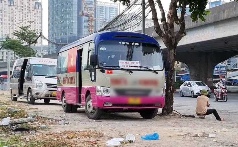Leaving the roadway, passenger buses climb onto the sidewalk in Hanoi