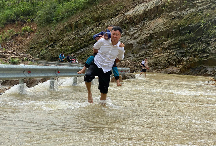Teacher Nguyen Chi Anh carries students through deep floodwaters to safely return to school after storm No. 3. Photo: Interviewee