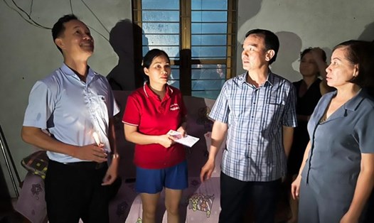 Ông Lê Thanh Xuân - Chủ tịch Công đoàn TKV (thứ 2 từ phải sang) động viên người lao động bị thiệt hại do bão lũ. Ảnh: Văn Tiến