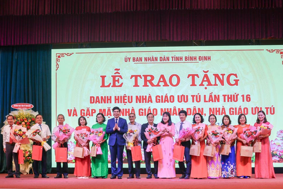 Vice Chairman of Binh Dinh Provincial People's Committee Lam Hai Giang and Vice Chairman of Vietnam Fatherland Front Committee of Binh Dinh Province Ho Thi Kim Thu presented flowers to teachers. Photo: Binh Dinh Information Portal