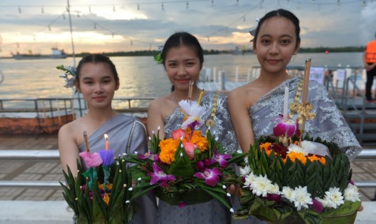 Các cô gái trong trang phục truyền thống của Thái Lan tạo dáng với hoa đăng bên sông Chao Phraya ở Bangkok, vào dịp lễ hội Loy Krathong. Ảnh: Xinhua