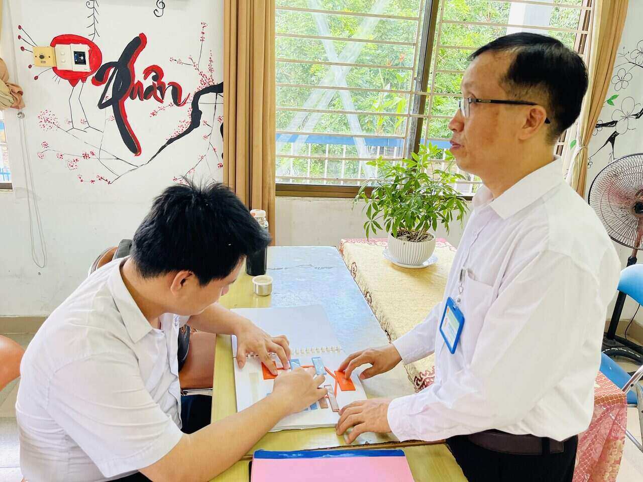 Teacher Hoang Van Khuong teaches history to blind students. Photo: Mai Huong
