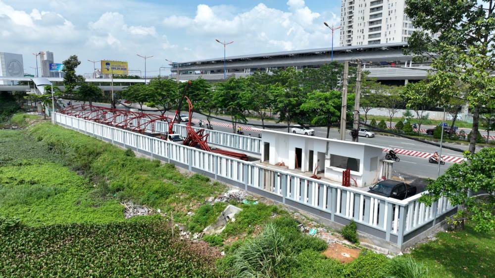 Cac bai giu xe ke cau di bo de phuc vu khach di vao ga Metro so 1 co ban da hoan thanh xong. Hien cong nhan dang lap dat them vom che. 