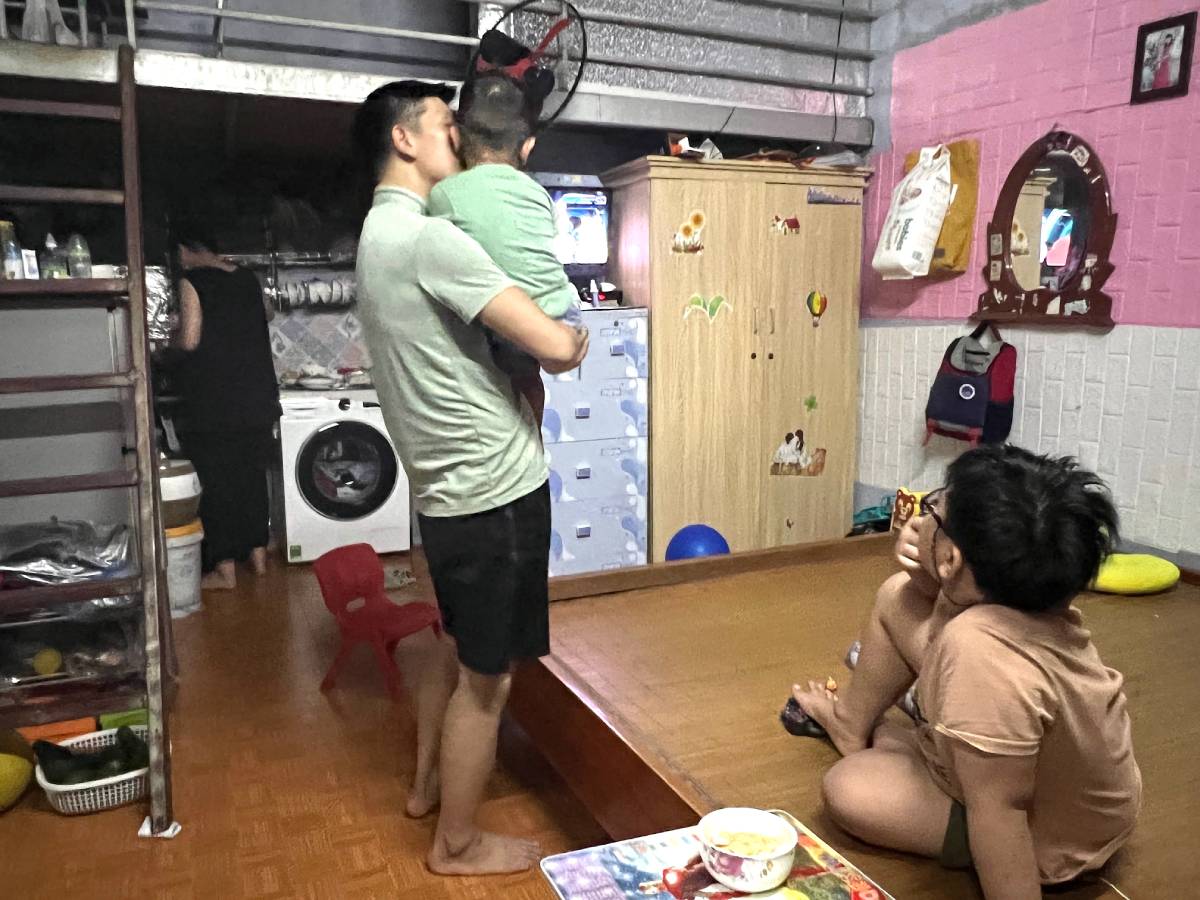 A male worker at Bac Thang Long Industrial Park (Dong Anh, Hanoi) takes care of his child in a rented room. Photo: Do ​​Phuong