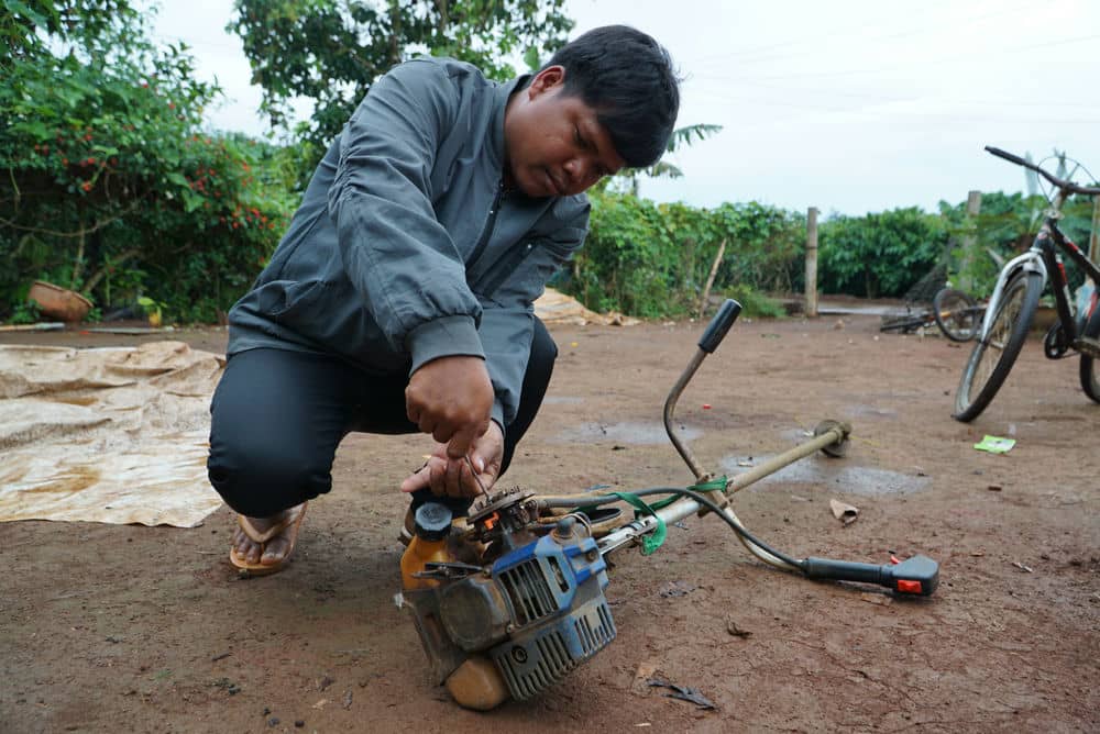 Anh Ksor Nam (34 tuoi, tru xa Ia Sao) sua lai may cat co. Anh: Phong Lan