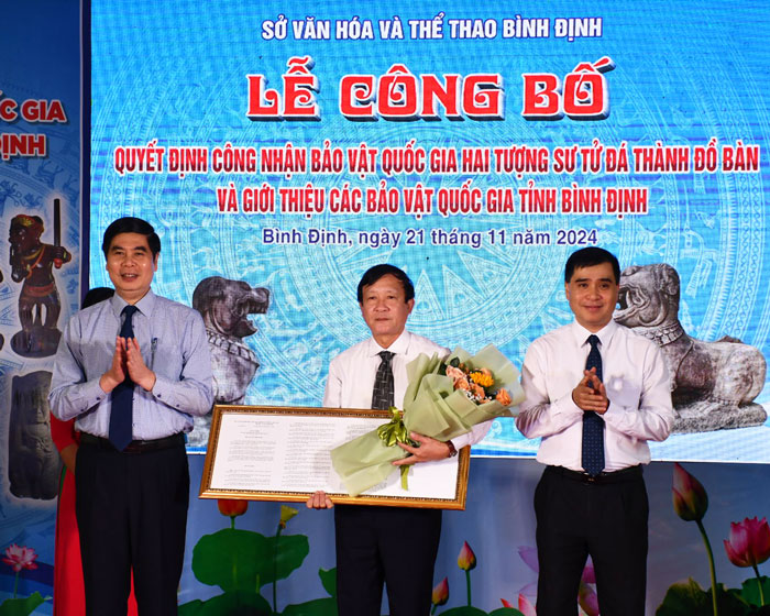 Pho Chu tich UBND tinh Lam Hai Giang (bia trai) va dai dien Cuc Di san trao quyet dinh cong nhan bao vat quoc gia cho lanh dao So Van hoa - The thao Binh Dinh. Anh: Xuan Nhan. 