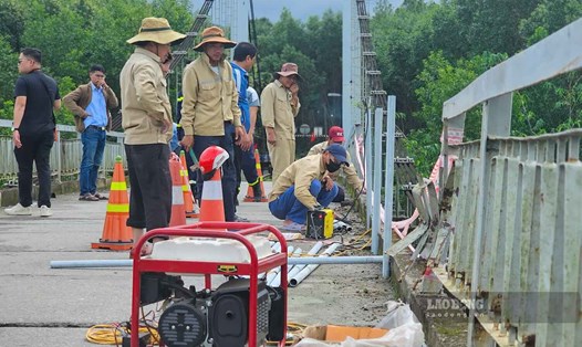 Lực lượng chức năng lắp lại lan can cầu Bình Thành bị hư hỏng.