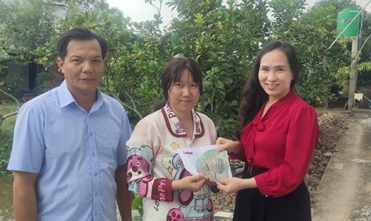 Diễm Quyên nhận số tiền hỗ trợ từ bạn đọc Báo Lao Động. Ảnh: Xuân Nhi