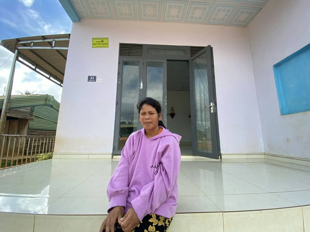 Ms. H'Bot (Mrs. H'Brai's daughter) in front of her newly built, solid and spacious house. Photo: Tra My