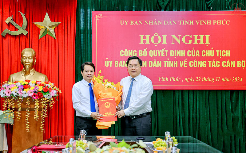 Chu tich UBND tinh Vinh Phuc Tran Duy Dong tang hoa va trao quyet dinh cho ong Le Anh Tan.  