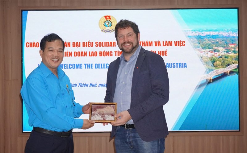 Chairman of the Thua Thien Hue Provincial Federation of Labor Le Minh Nhan presented a souvenir to the Solidar - Austria delegation, and hoped that the two sides would promote cooperation to care for workers and laborers. Photo: Nha Phuong.