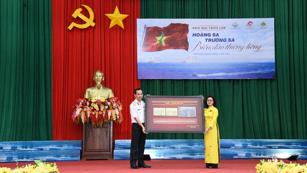 The State Records and Archives Department presented the Naval Region 5 Command with a printed copy of King Le Thanh Tong's Edict on maintaining the country's borders from the Nguyen Dynasty Woodblocks during the exhibition. Photo: Van Dinh