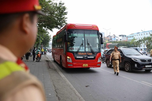 Cảnh sát giao thông xử lý xe dừng đỗ đón khách trên đường Phạm Hùng (Hà Nội). Ảnh: Tuấn Hiệp