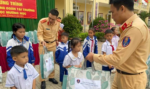 Lãnh đạo, cán bộ, chiến sĩ Phòng CSGT Công an tỉnh Nghệ An tặng quà cho các em học sinh Trường Tiểu học Mường Nọc. Ảnh: Ngọc Anh