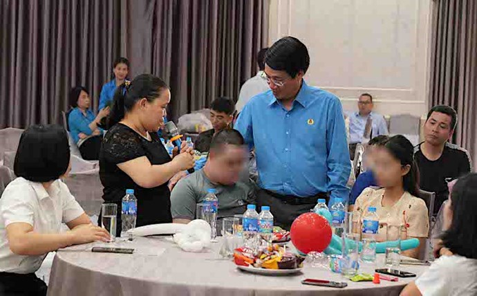 Mr. Le Phan Linh - Chairman of the Trade Union of Vietnam National Shipping Lines encouraged the child of a female worker with a congenital disability. Photo: Linh Chu