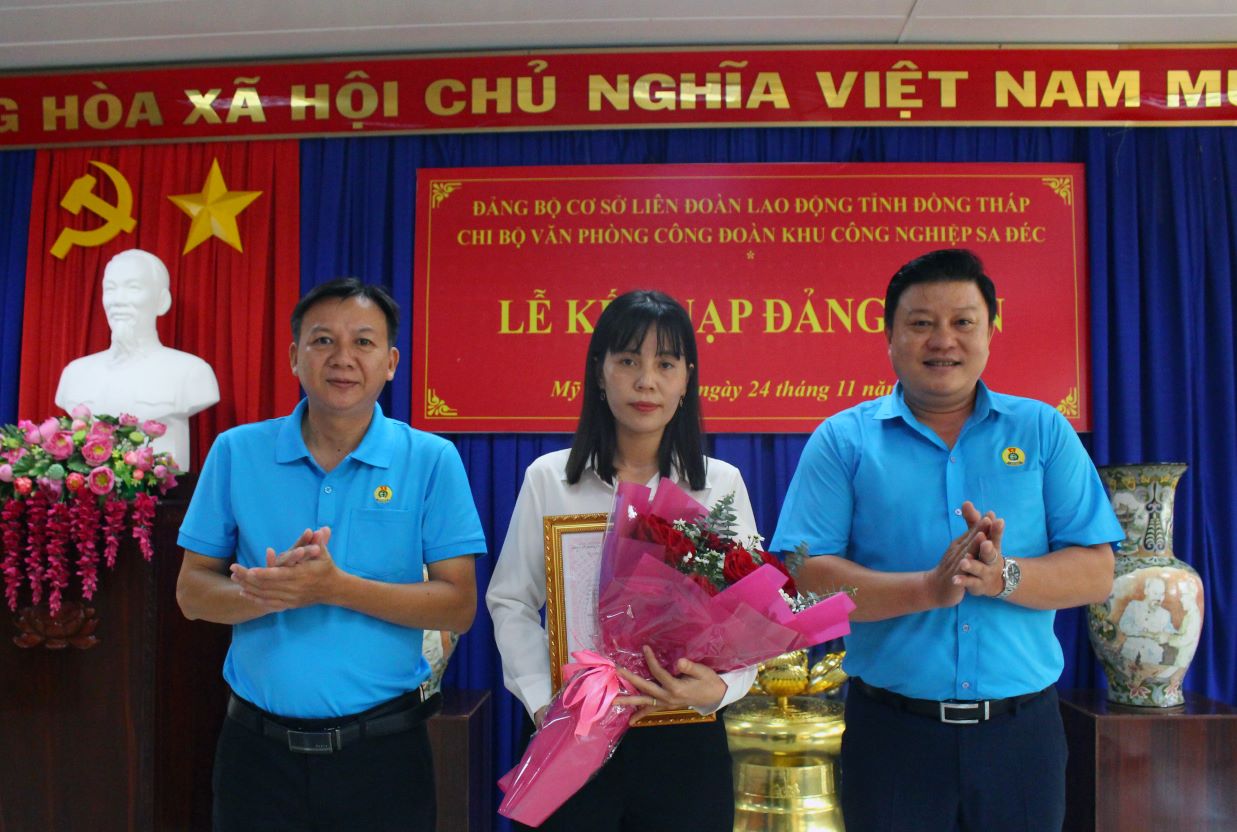 Nguyen Thanh Nghia – Pho Bi thu Dang uy co so LDLD tinh Dong Thap, va ong Nguyen Thanh Nhan - Bi thu Chi bo Van phong Khu cong nghiep Sa Dec trao quyet dinh ket nap dang vien moi va hoa chuc mung Phan Thuy Lam duoc ket nap dang. Anh: Thanh Mai. 