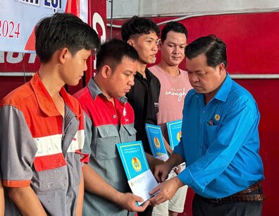 Mr. Nguyen Hoai Tan, Chairman of the Vinh Loi District Labor Federation, presented the decision to admit new union members to workers who are auto mechanics. Photo: Nhat Ho