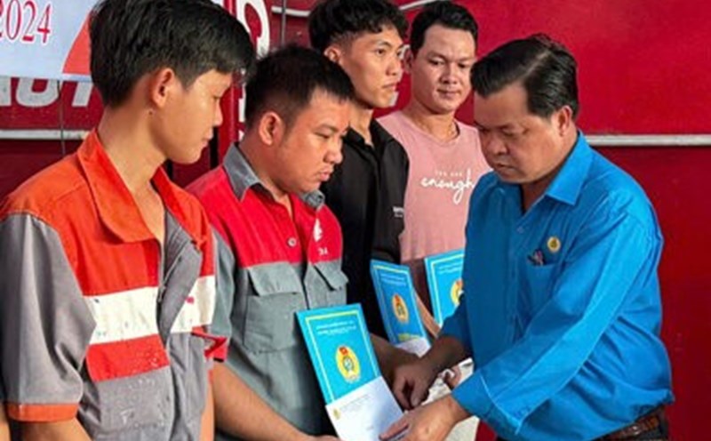 Mr. Nguyen Hoai Tan, Chairman of the Vinh Loi District Labor Federation, presented the decision to admit new union members to workers who are auto mechanics. Photo: Nhat Ho