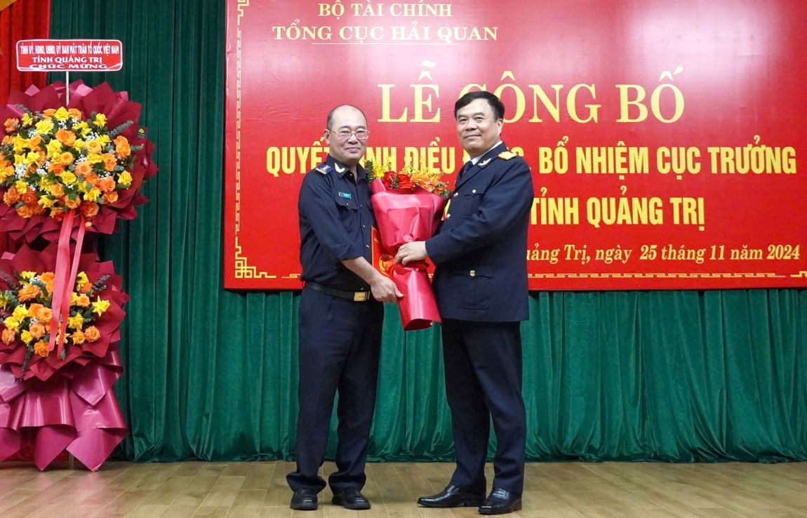 Mr. Chu Quang Hai (left) received congratulatory flowers for his transfer and appointment to a new task. Photo: Hung Tho.