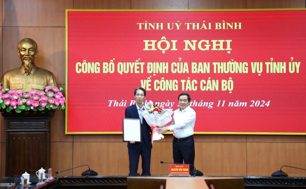 Standing Deputy Secretary of the Provincial Party Committee, Chairman of the People's Council of Thai Binh Province Nguyen Tien Thanh (right cover) presents the decision and flowers to congratulate the new Deputy Head of the Provincial Party Committee's Organization Board Nguyen Duy Chien. Photo: Ha Linh/thaibinh.gov.vn