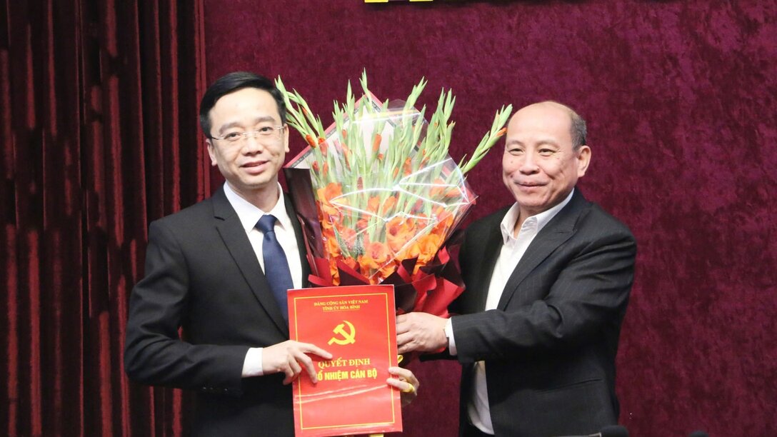Standing Deputy Secretary of Hoa Binh Provincial Party Committee Bui Duc Hinh presents the decision to Mr. Nguyen Dang Khoa (wearing glasses). Photo: Le Hue.