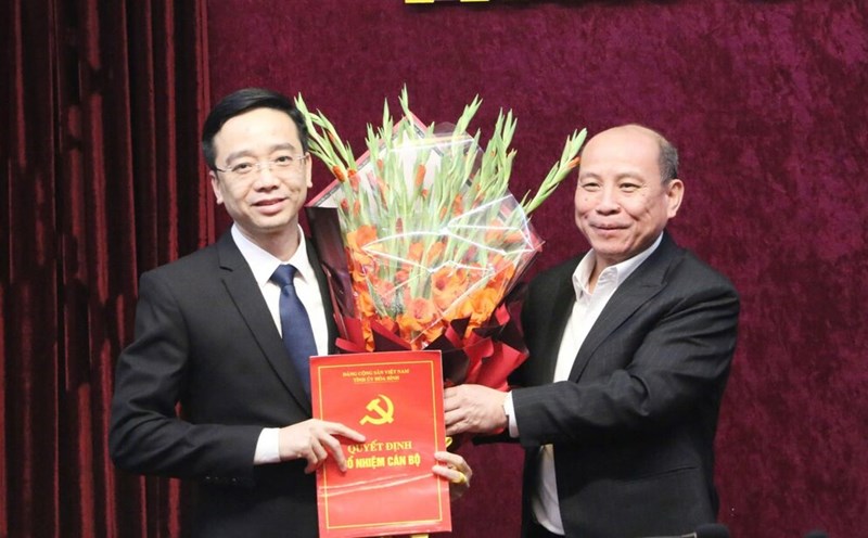 Standing Deputy Secretary of Hoa Binh Provincial Party Committee Bui Duc Hinh presents the decision to Mr. Nguyen Dang Khoa (wearing glasses). Photo: Le Hue.