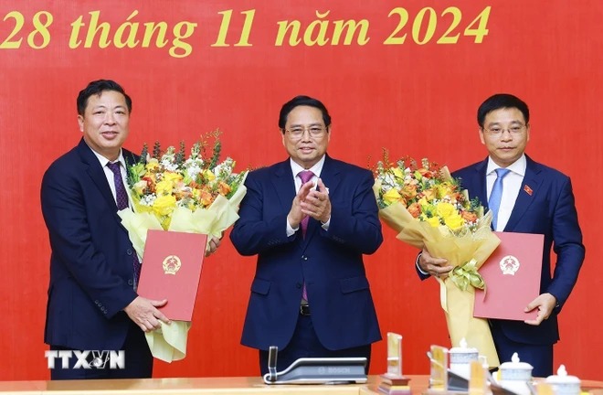 Prime Minister Pham Minh Chinh presented the President's decision appointing Mr. Nguyen Van Thang as Minister of Finance and Mr. Tran Hong Minh as Minister of Transport. Photo: Duong Giang/VNA