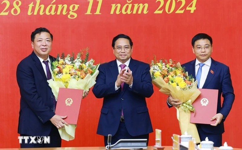 Prime Minister Pham Minh Chinh presented the President's decision appointing Mr. Nguyen Van Thang as Minister of Finance and Mr. Tran Hong Minh as Minister of Transport. Photo: Duong Giang/VNA