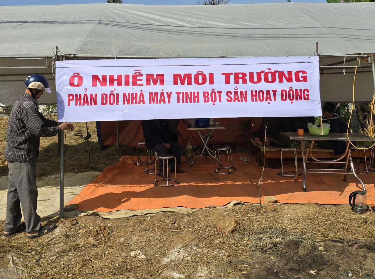 Người dân thôn Xát và thôn Me (xã Sơn Lai, huyện Nho Quan, Ninh Bình) dựng lều ngay trước cổng Nhà máy chế biến tinh bột sắn Elmaco Ninh Bình để phản đối vì cho rằng Nhà máy này xả thải gây ô nhiễm môi trường. Ảnh: Nguyễn Trường