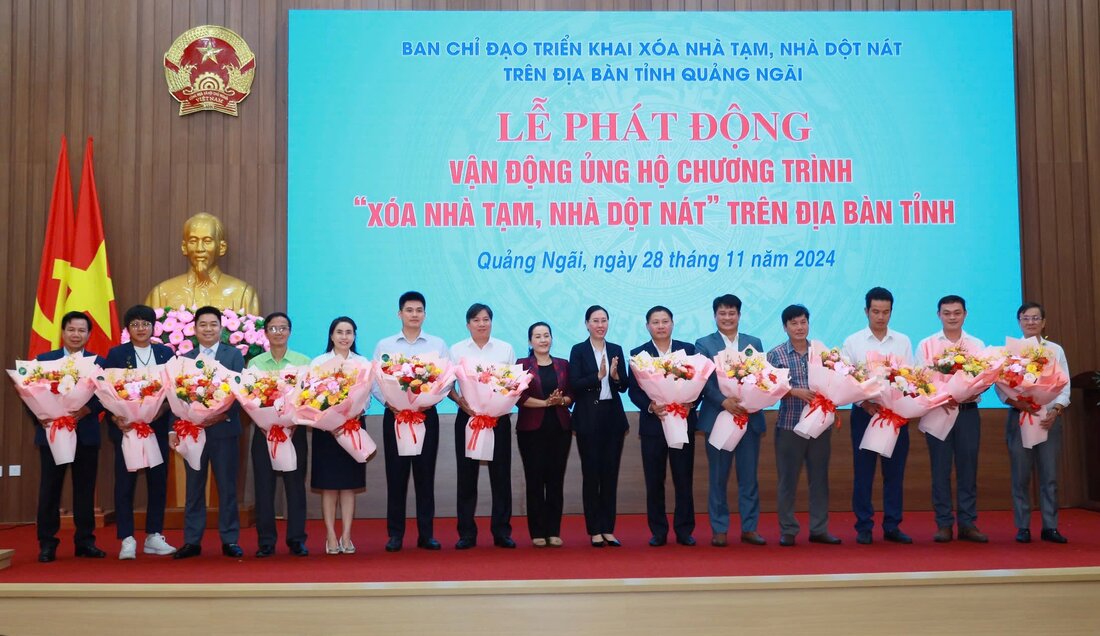 Ba Bui Thi Quynh Van - Bi thu Tinh uy Quang Ngai (dung thu 7 tu phai sang) tang hoa cam on cac don vi, doanh nghiep, nha hao tam da ung ho chuong trinh xoa nha tam, nha dot nat. Anh: Vien Nguyen