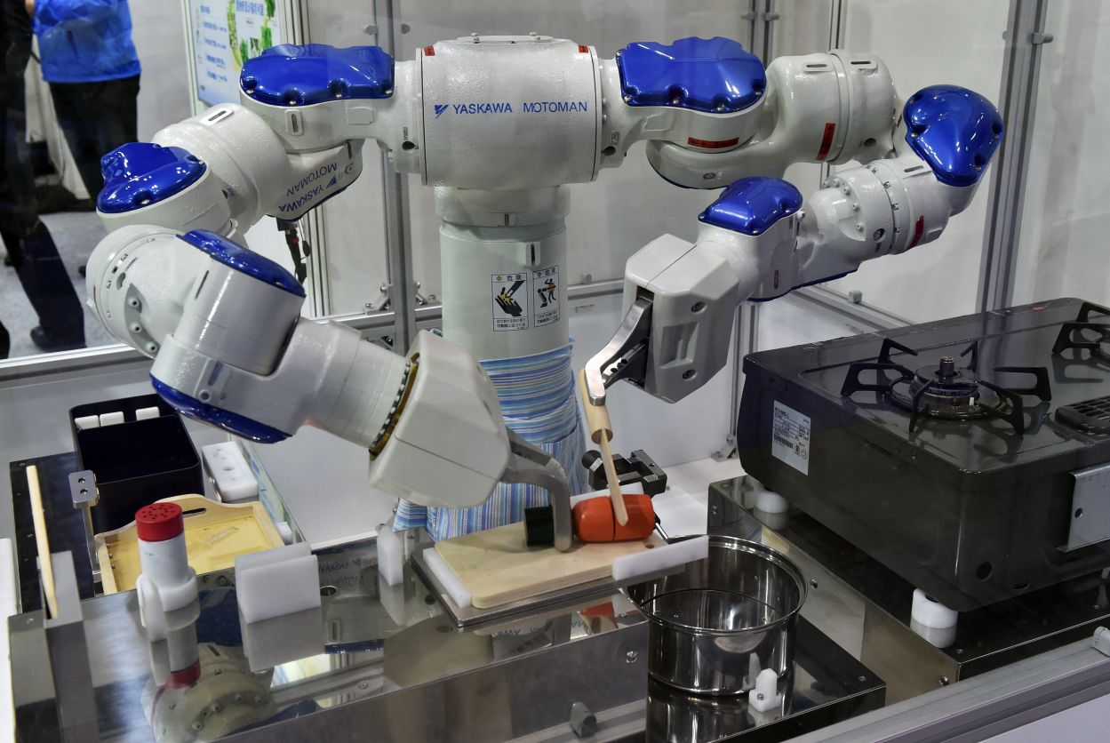 Motoman Robot of Yaskawa Electric Company (Japan) is demonstrating cooking. Photo: AFP