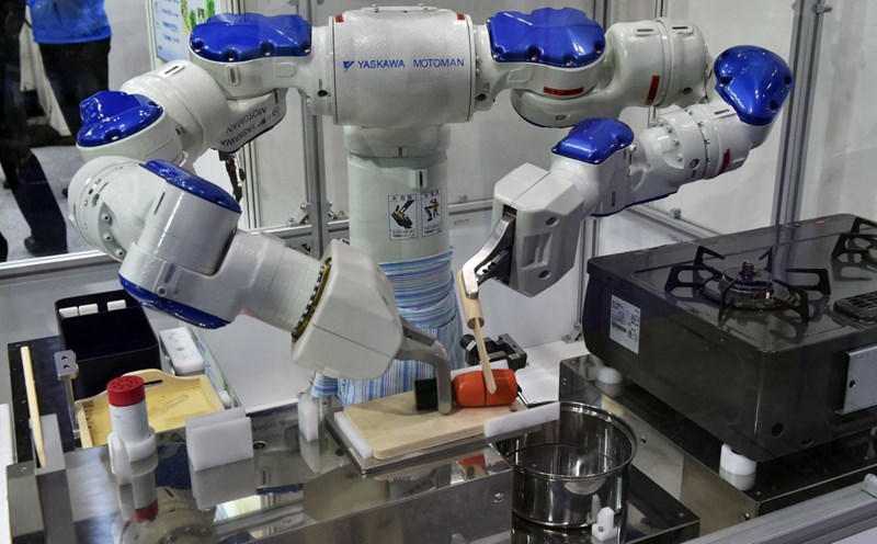 Motoman Robot of Yaskawa Electric Company (Japan) is demonstrating cooking. Photo: AFP