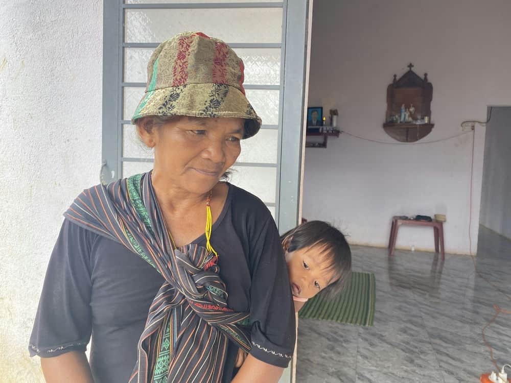 Mrs. H'Mbeo and her grandchildren in their new, spacious house. Photo: Phong Nha