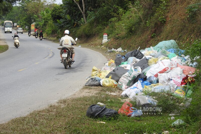 Bãi rác lớn áp sát taluy dương ven đường. Ảnh: Tô Công.