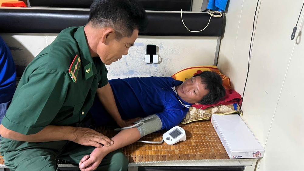 Medical staff on a rescue ship provide medical care to a crew member whose barge sank in Phu Quoc waters. Photo: Border Guard provided