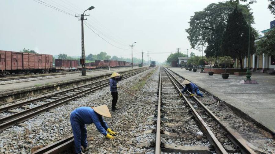 Workers maintain the passenger railway area. Photo: Phung Minh