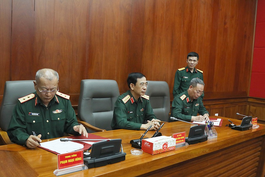 Dưới sự chứng kiến của Đại tướng Phan Văn Giang, Trung tướng Phạm Ngọc Hùng và Trung tướng Trần Công Chính ký kết biên bản bàn giao chức trách, nhiệm vụ Tổng Cục trưởng Tổng cục II. Ảnh: Bộ Quốc phòng