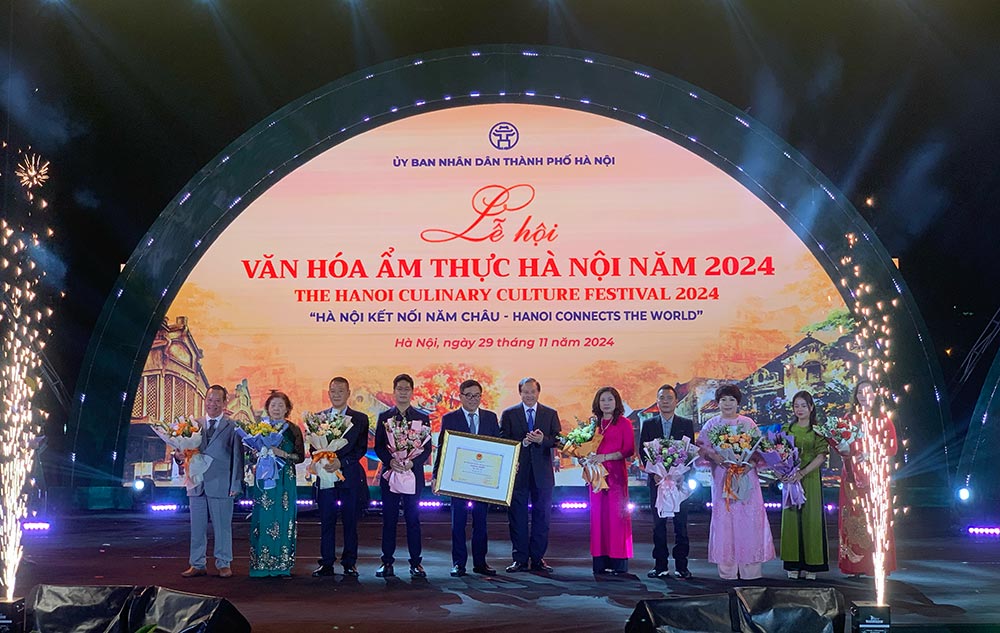 Thu truong Bo VHTT&DL Ta Quang Dong trao Quyet dinh ghi danh “Pho Ha Noi” la Di san van hoa phi vat the quoc gia cho lanh dao So VH&TT Ha Noi cung cong dong chu the pho Ha Noi. Anh: Y Yen