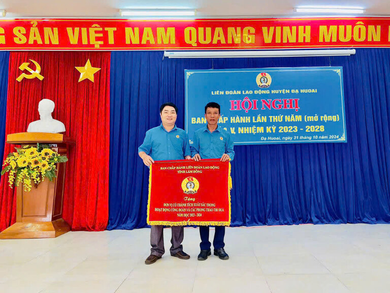 Chairman of Da Huoai District Labor Federation - Mr. Tran Kim Anh (right cover) awarded the excellent emulation flag of Lam Dong Provincial Labor Federation to the grassroots union. Photo. THU GIANG