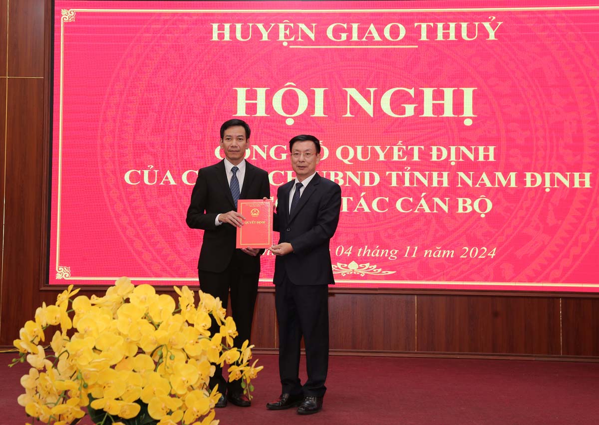 Chairman of Nam Dinh Provincial People's Committee Pham Dinh Nghi presented the Decision and flowers to congratulate the new Chairman of Giao Thuy District People's Committee Dinh Hoang Dung. Photo: Nguyen Van