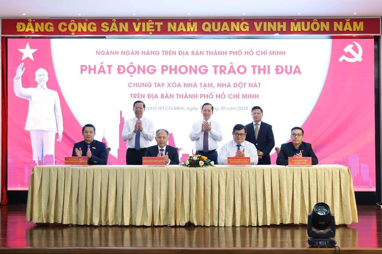Mr. Nguyen Hoang Hai - Q. General Director of Eximbank (far left) and representatives of banks signed a cooperation agreement with the Vietnam Fatherland Front Committee of Ho Chi Minh City to implement the program "Joining hands to eliminate temporary and dilapidated houses in Ho Chi Minh City".