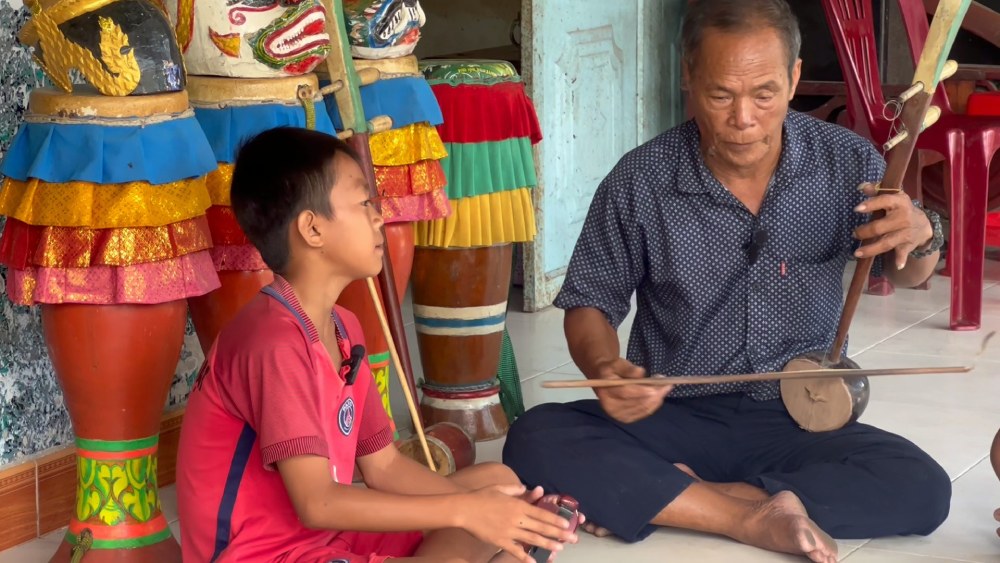 Meritorious artist Danh Be plays the instrument and guides children in traditional Khmer art. Photo: Xuan Nhi