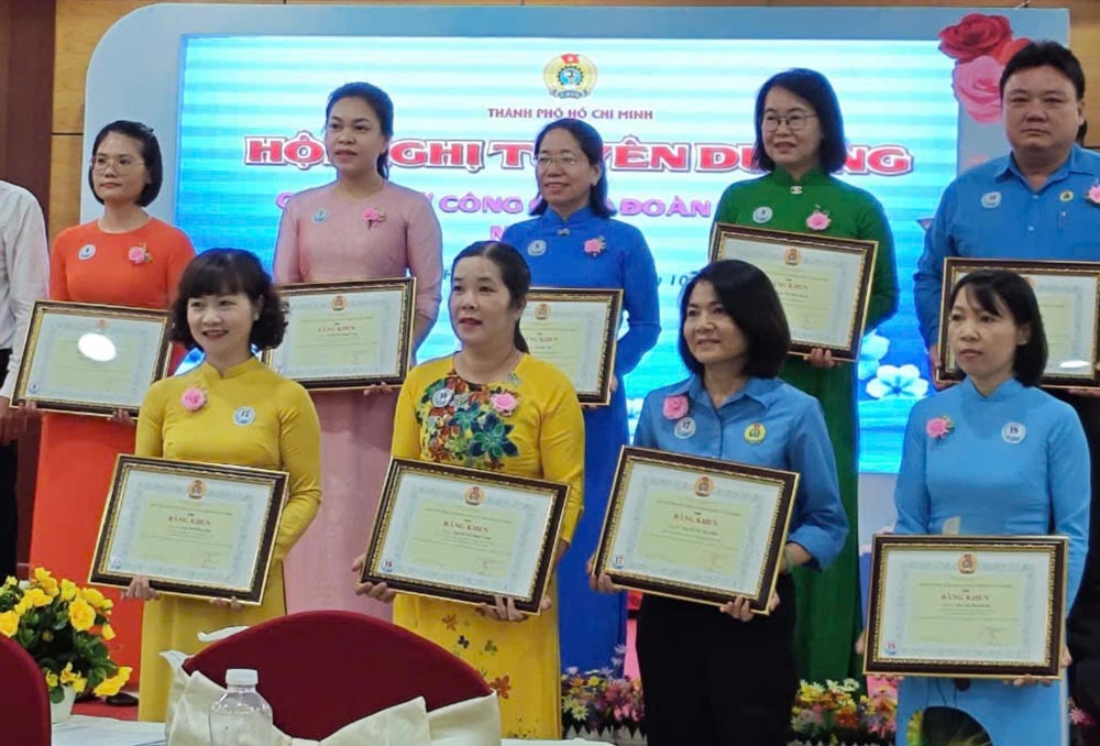Ms. Tran Thi Hong Gam (front row, left cover) and female union officials were honored by the Ho Chi Minh City Labor Federation. Photo: Duc Long