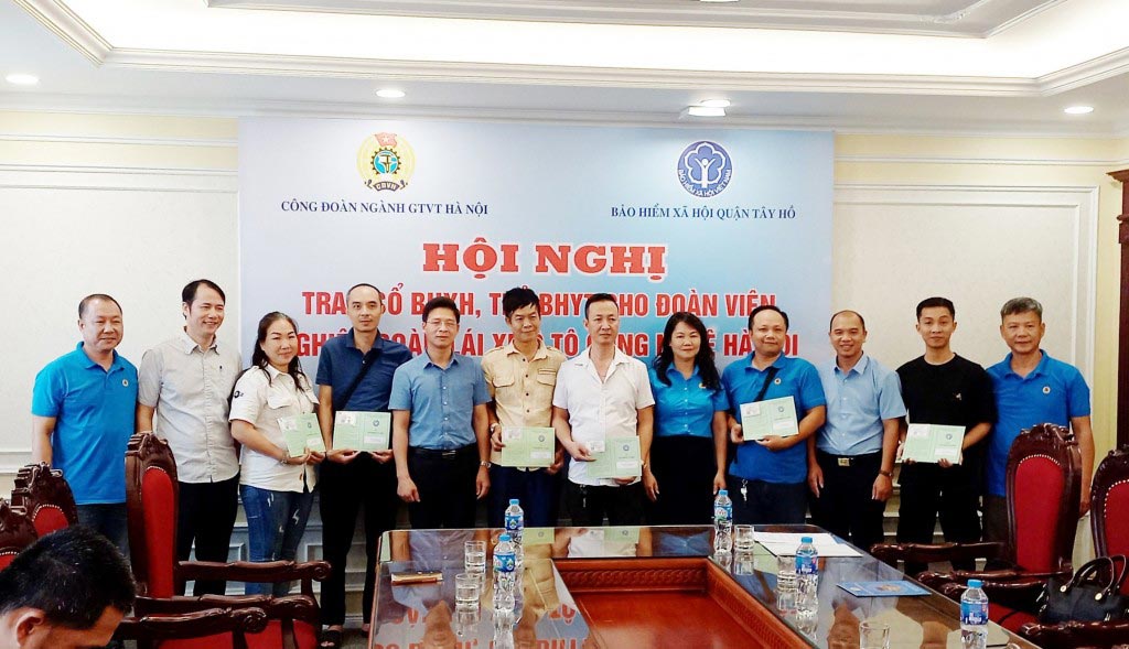 Representatives of the Hanoi Transport Industry Union, Tay Ho District Social Insurance and Hanoi Technology Car Drivers Union presented health insurance cards and social insurance books to union members. Photo: Trade Union