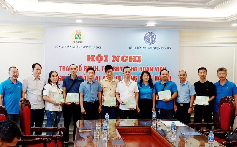 Representatives of the Hanoi Transport Industry Union, Tay Ho District Social Insurance and Hanoi Technology Car Drivers Union presented health insurance cards and social insurance books to union members. Photo: Trade Union