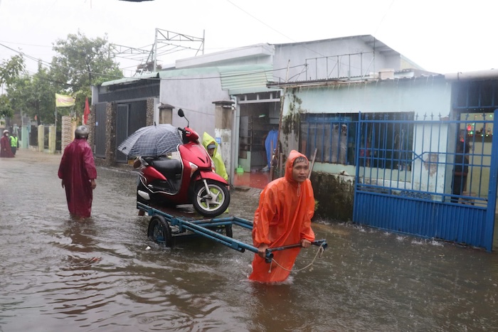 Nguoi dan dung xe bo de dua xe may den noi cao rao. Anh: Nguyen Linh