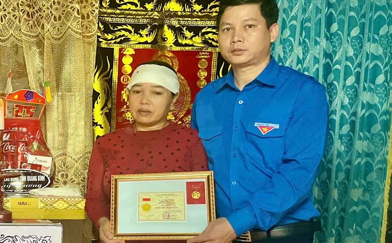 Awarding the "Brave Youth" badge to a young man in Quang Binh who was swept away by flood. Photo: L. Hoai