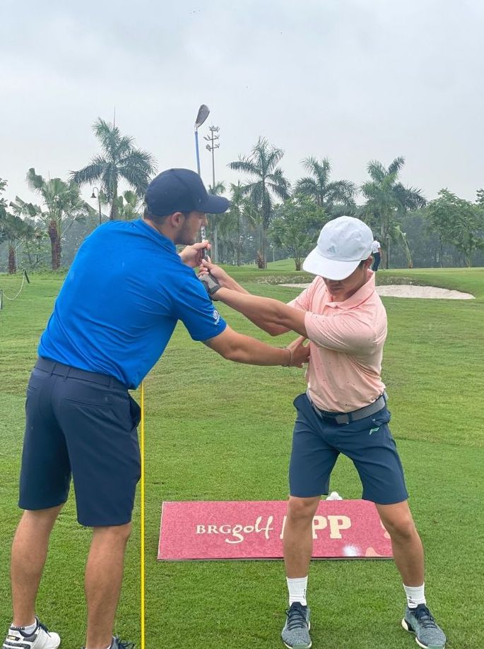 Ong Eugene Marais Giam doc Dao tao Hoc vien Gon Jack Nicklaus (ao xanh) dang huong dan hoc vien.