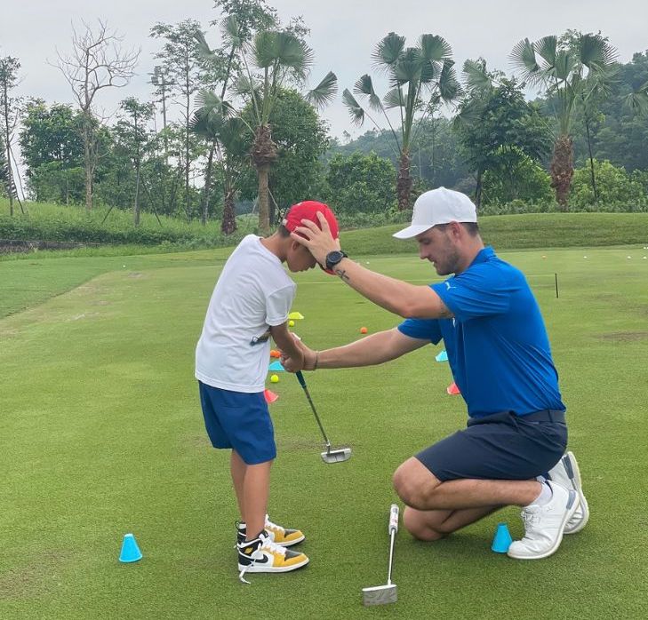 Ong Eugene Marais - Giam doc Dao tao Hoc vien Gon Jack Nicklaus (ao xanh) - dang huong dan hoc vien.