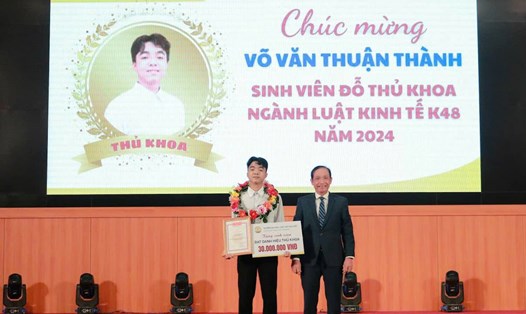 PGS.TS Đoàn Đức Lương - Hiệu trưởng Trường Đại học Luật, Đại học Huế khen thưởng tân sinh viên Võ Văn Thuận Thành - Thủ khoa K48. Ảnh: H. Hướng.